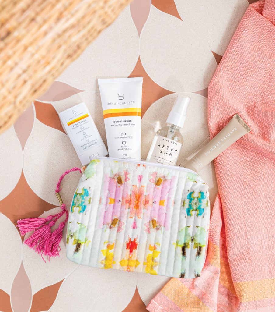 Multicolored makeup bag with various sunscreens peeking out