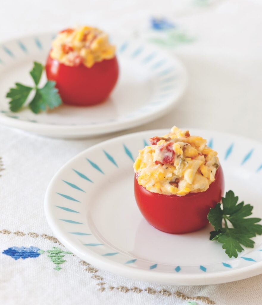 Tomatoes filled with pimiento cheese on white plates