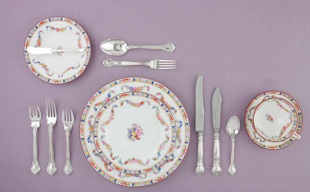 A photo of china in a proper table setting