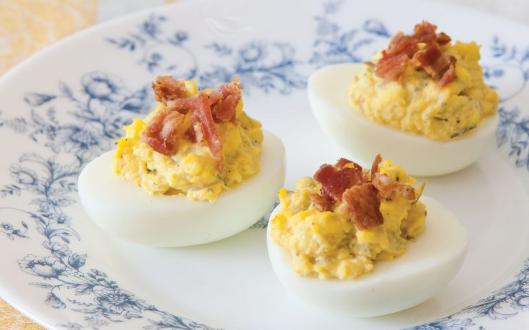 Three Bacon-Topped Deviled Eggs on a blue-and-white plate