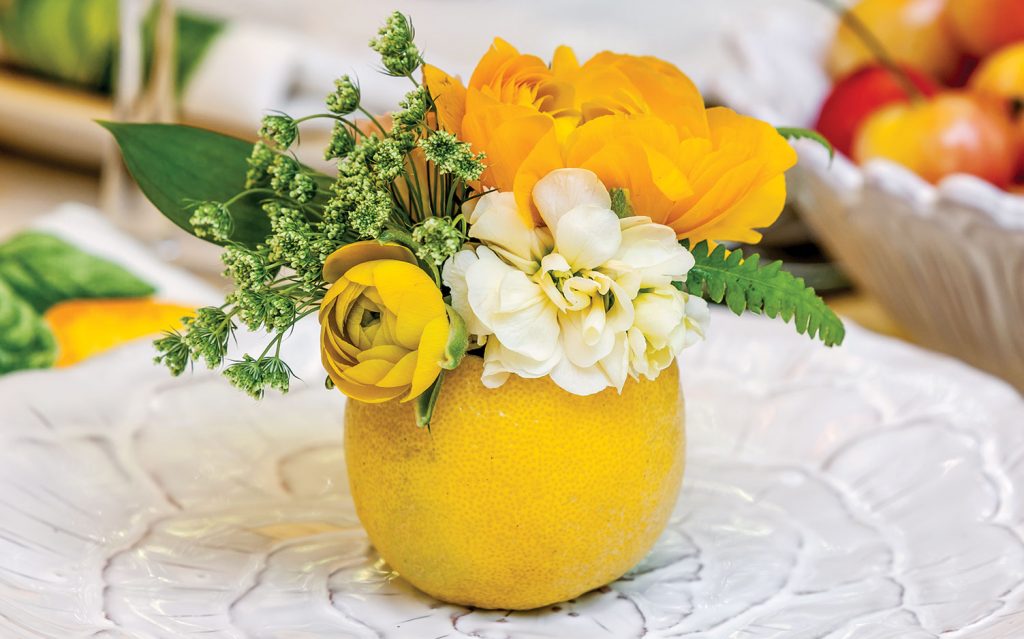 A picture of a summer floral arrangement in a fruit-turned-vase