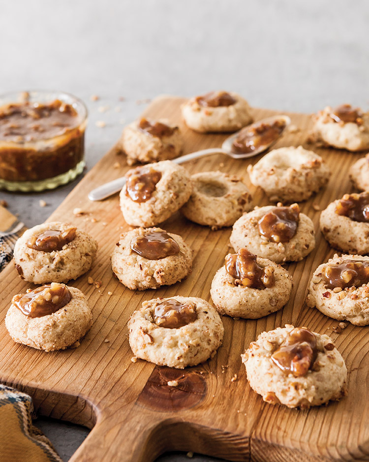 Old-Fashioned Goodies Pecan Pie Thumbprint Cookies served on a wooden cutting board