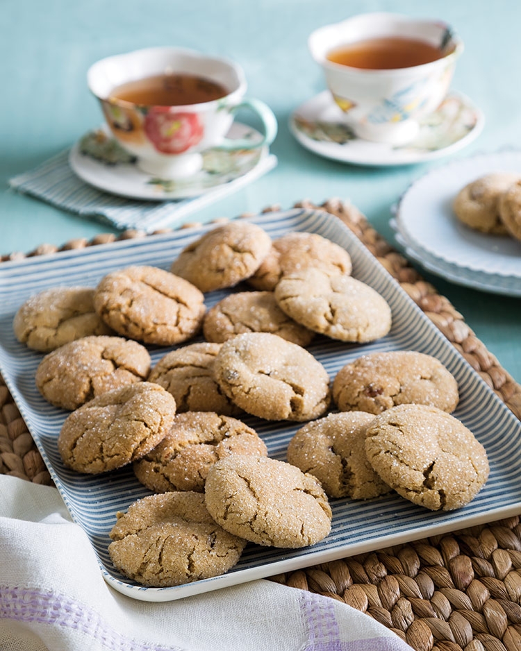 Old-Fashioned Goodies Sorghum Spice Cookies served on a striped tray next to floral tea cups