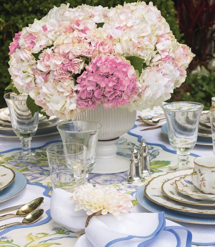 Blue-and-white tabletop with centerpiece of lush pink and white hydrangeas