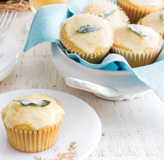 Orange Sage Muffins, one on a white plate and several in a white bowl lined with an aqua linen