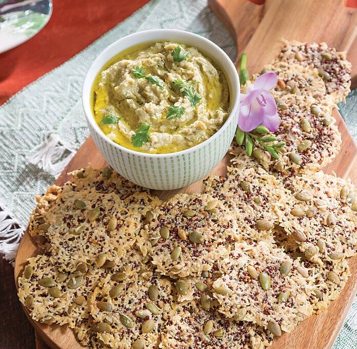 Cilantro Hummus and crackers on a wooden board