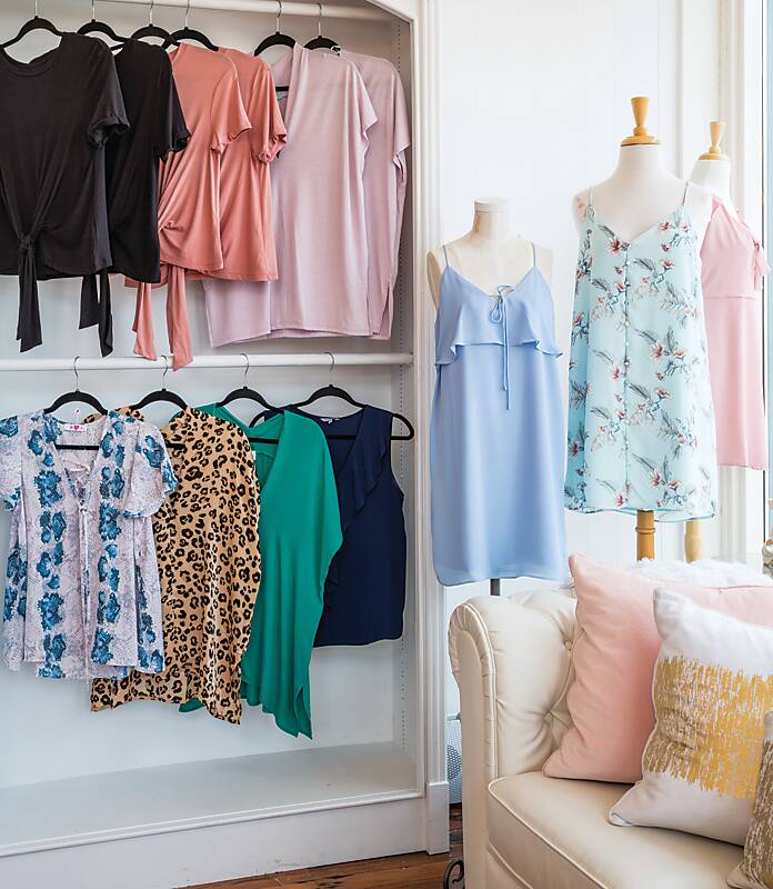 Colorful women's clothing hung on white racks and adorning mannequins at Fincher's Inc. boutique 
