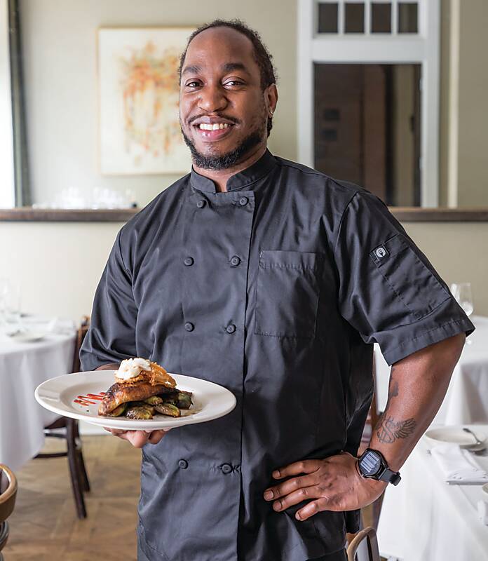 Chef holding a plate of food at Giardina's at The Alluvian Hotel