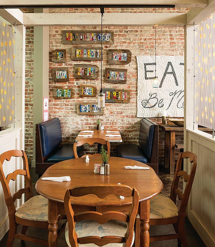 Dining room decorated with art on a brick wall at Fan and Johnny's restaurant