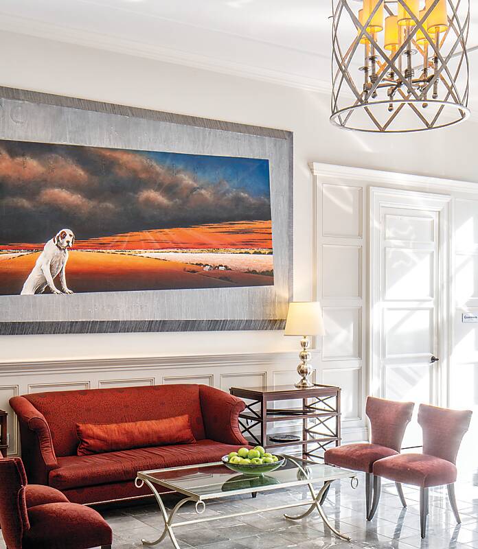 Lobby decorated with red furnishings and landscape painting at The Alluvian Hotel