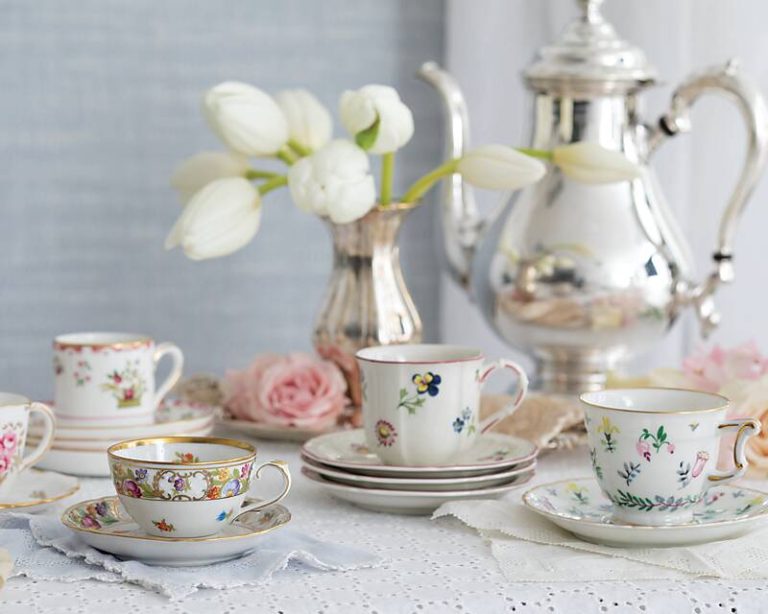 Demitasse cups and saucers next to a silver coffee service