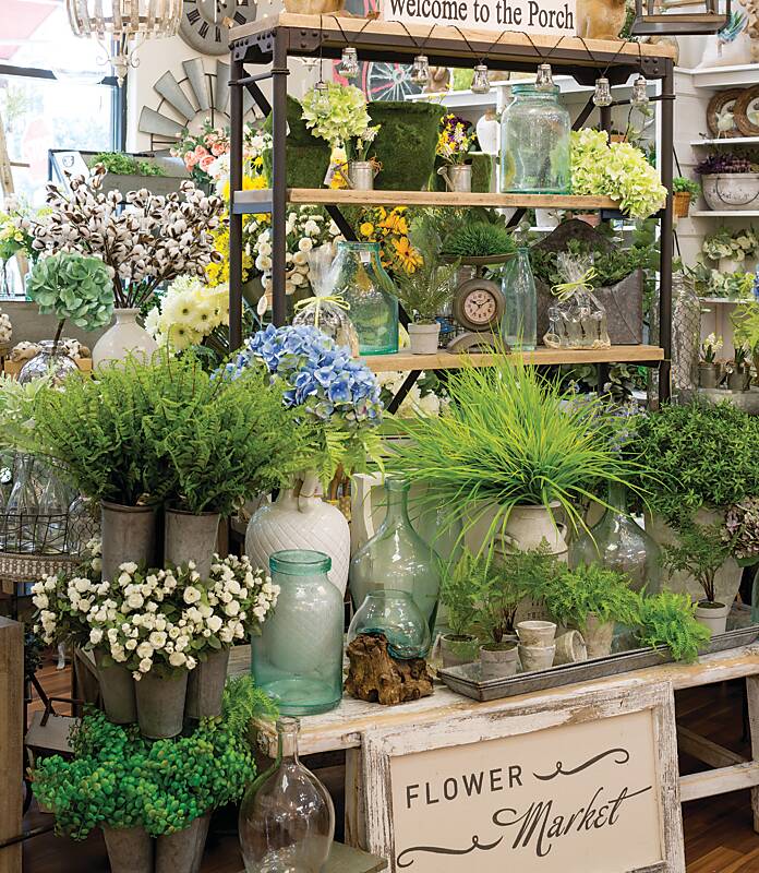 Myriad faux plants in pots and vases on shelves