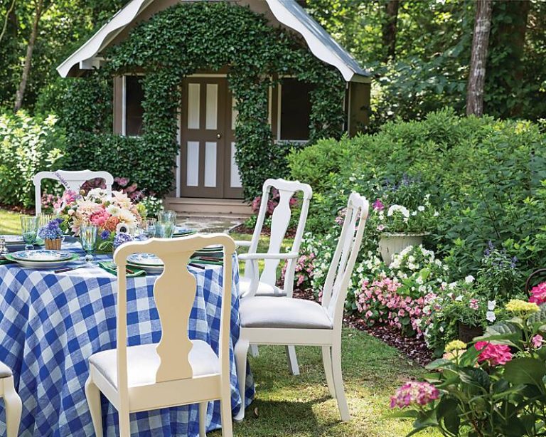Table with blue-and-white gingham cloth set in a garden