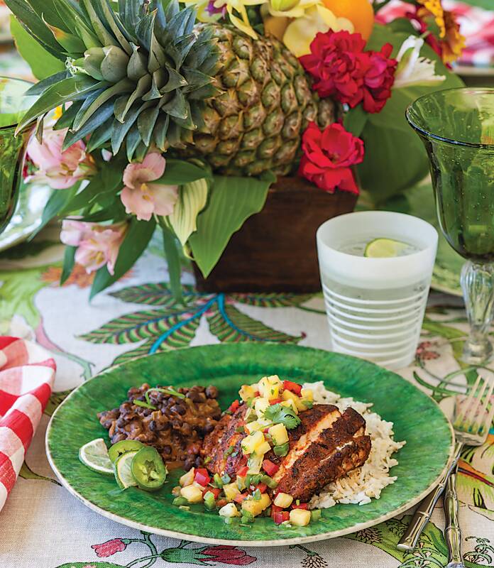 Blackened Grouper with Pineapple Relish on a green plate with rice and beans