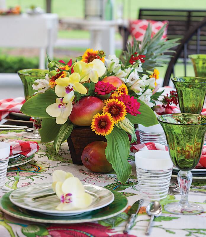 Taste of the Tropics table set with tropical flowers and green glassware