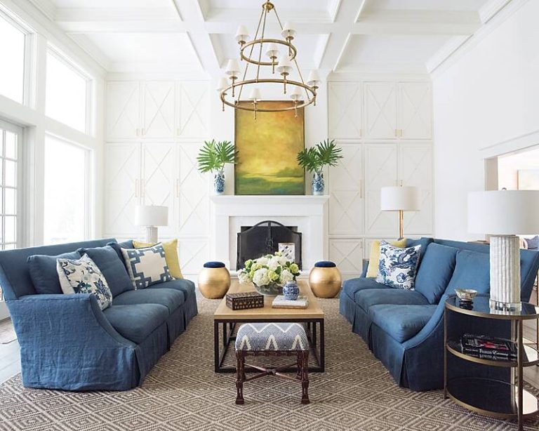 White living room featuring blue sofas and yellow artwork