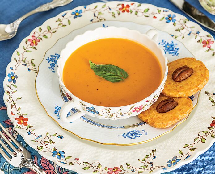 Tomato soup and two cheese pennies served in white floral china