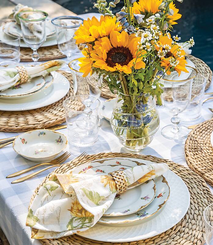 Table setting of white and floral dishes with sunflower centerpiece