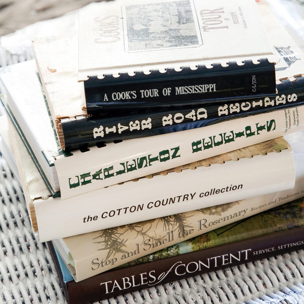 Stack of cookbooks for Denise Gee's essay "Recipe for a Cookbook"