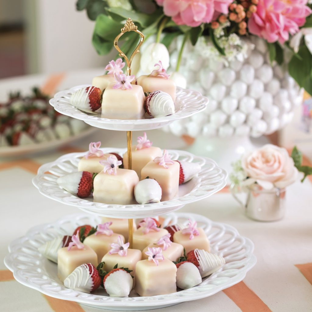 Lemon-Blackberry Petit Fours on a tiered stand with white chocolate-covered strawberries