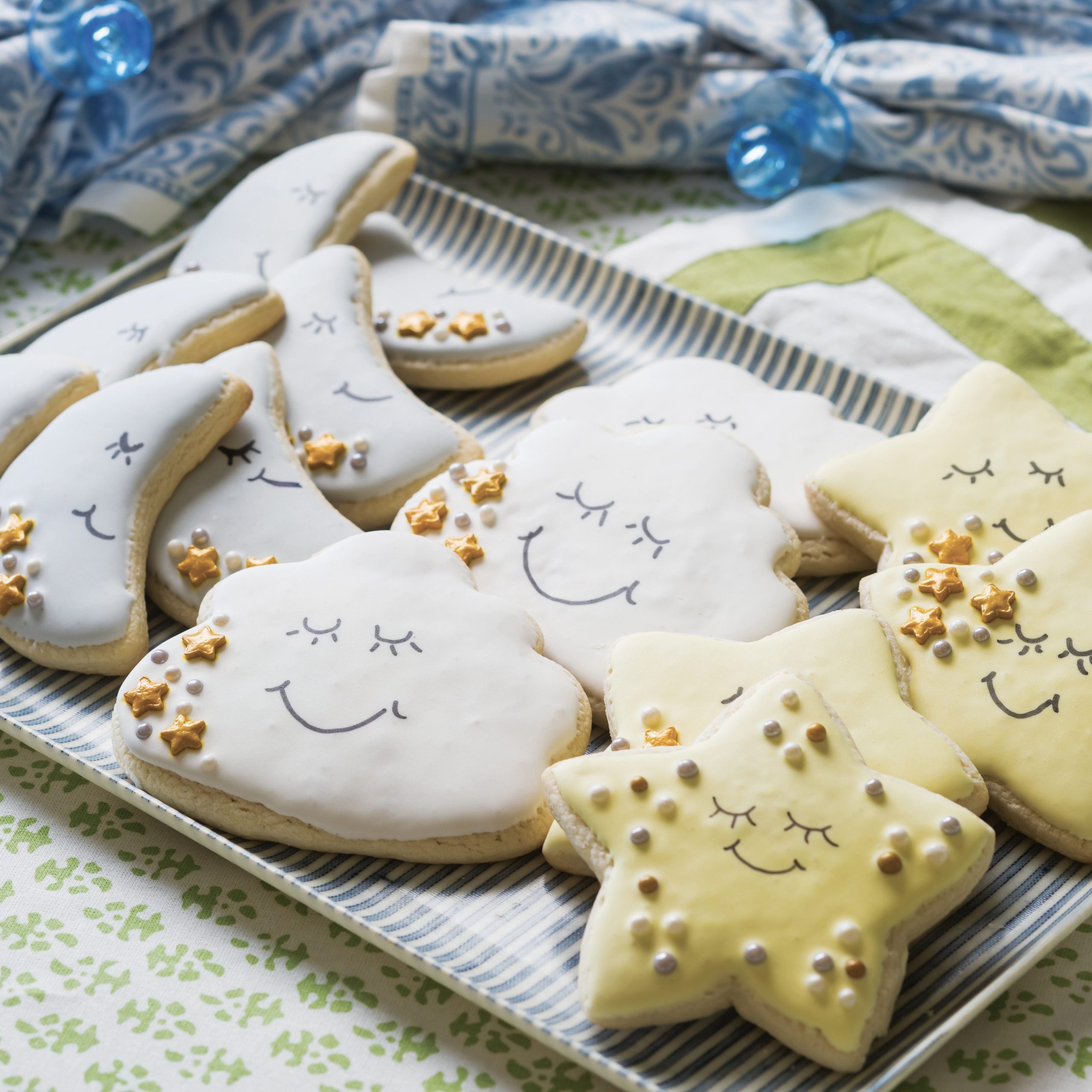 Moon shaped cookies, cloud shaped cookies, and star shaped cookies painted with smiling faces