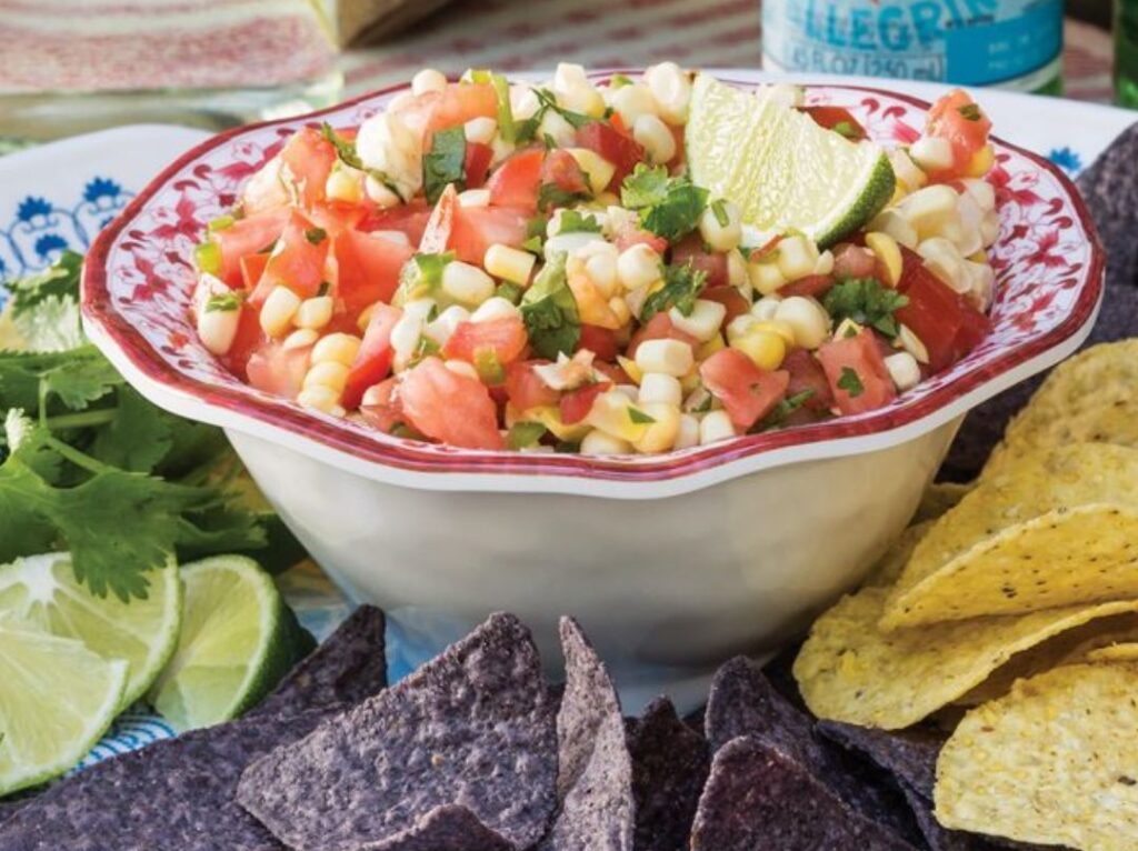 Bowl of corn and tomato salsa with chips for snacks and sides