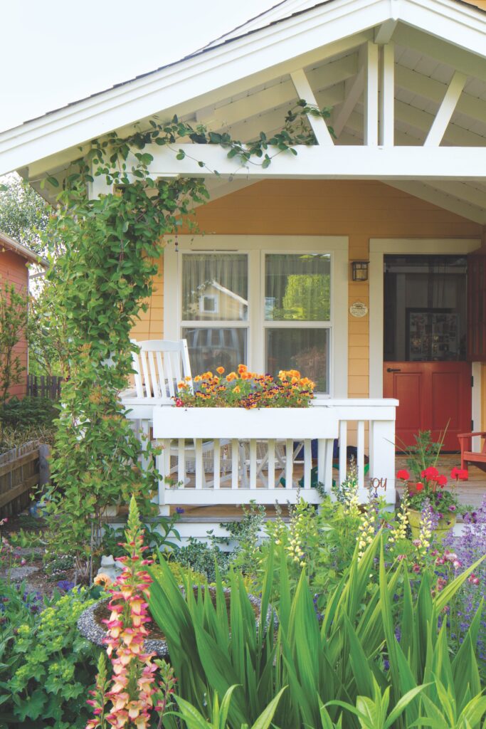 Yellow cottage front entry with flowers