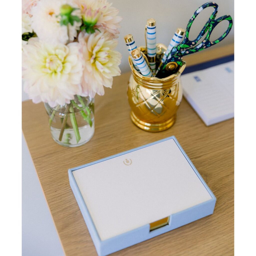 Blue desk jotter and flowers