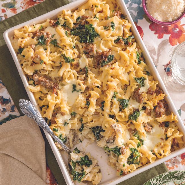 Baked Pasta with Greens and Sausage in a white baking dish