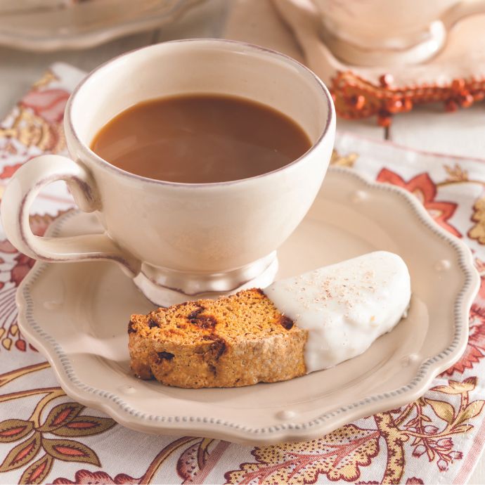 Pumpkin Spice Biscotti on a plate with a cup of coffee
