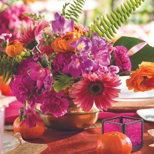 Hot pink and orange flowers in a brass vessel