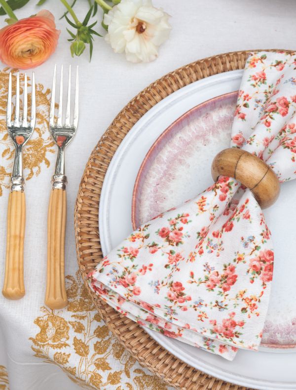 A coral, pink, and white place setting with rattan accents