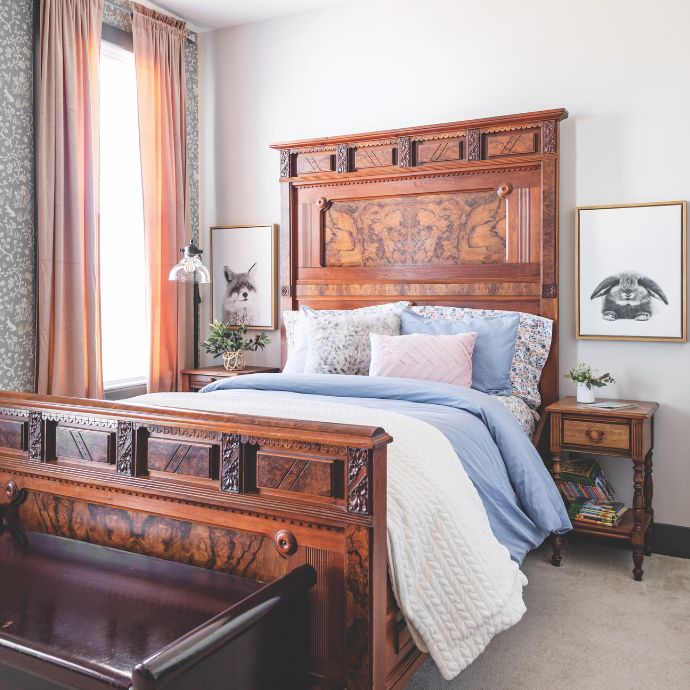 An antique bed and nightstands framed by black-and-white animal artwork
