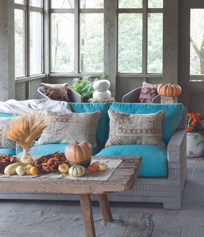 Porch with teal sofa and pumpkins