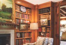 Fine Antiques Accentuate This Home’s Architectural Grandeur At-home library with books and fine antiques on wooden shelves