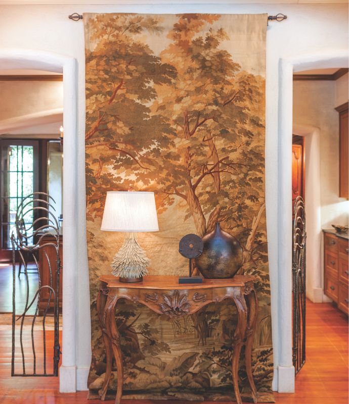 A floor to ceiling tapestry hung behind an accent table