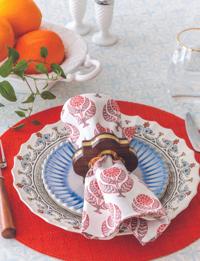 Bright red-orange place mat with china and block-print napkin