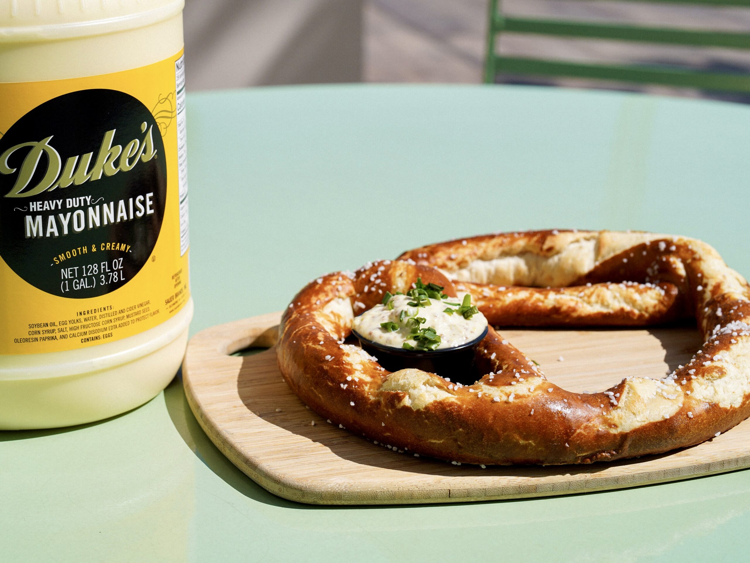 A large pretzel next to a jar of Duke's Mayo