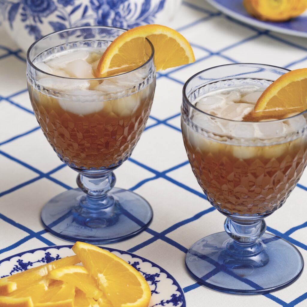 Orange iced tea in blue water goblets