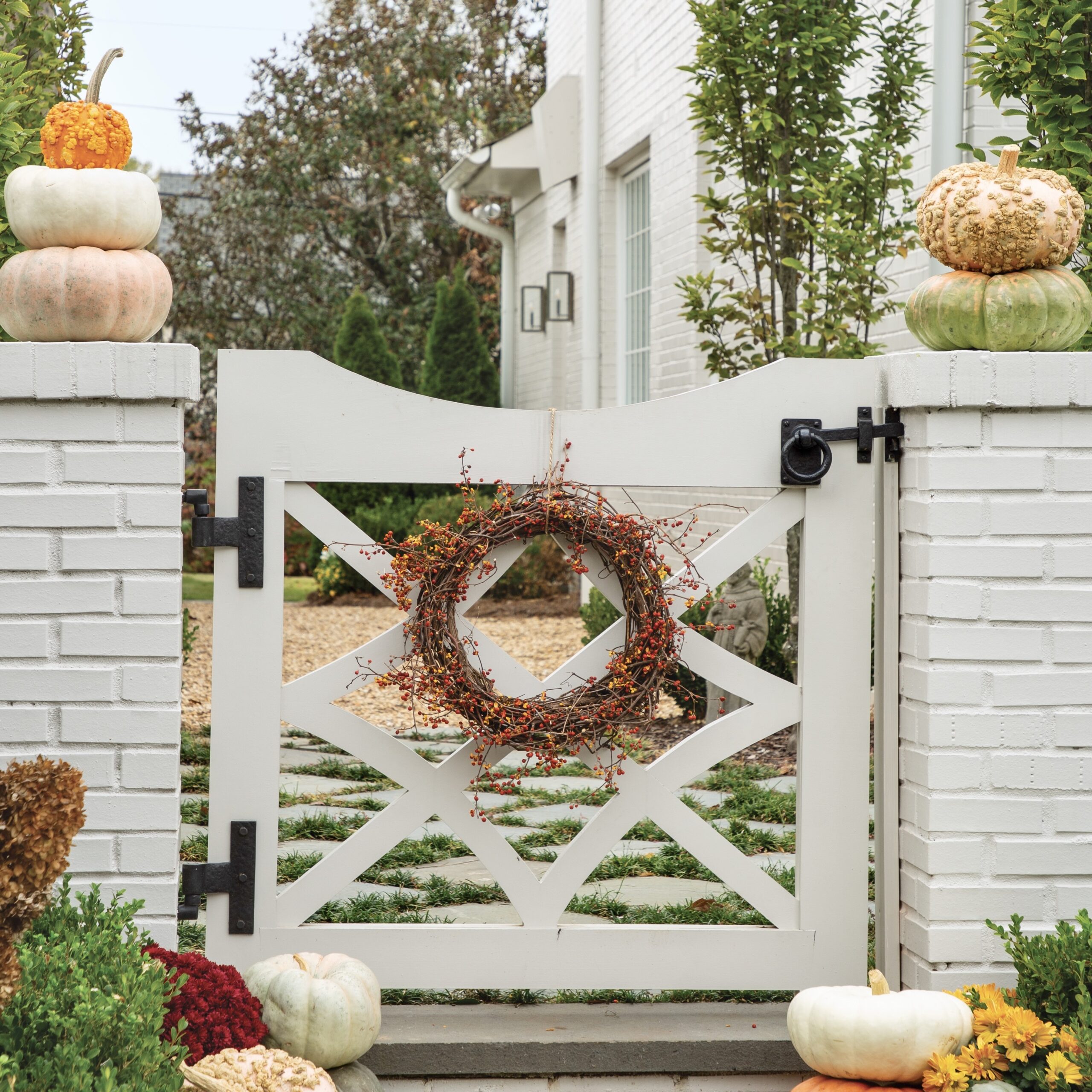 A white gate framed by pumpkins