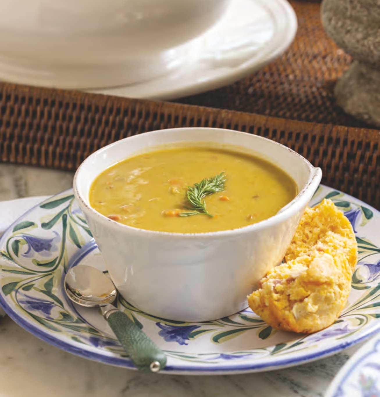 a bowl of split pea soup with ham and cheddar corn muffins