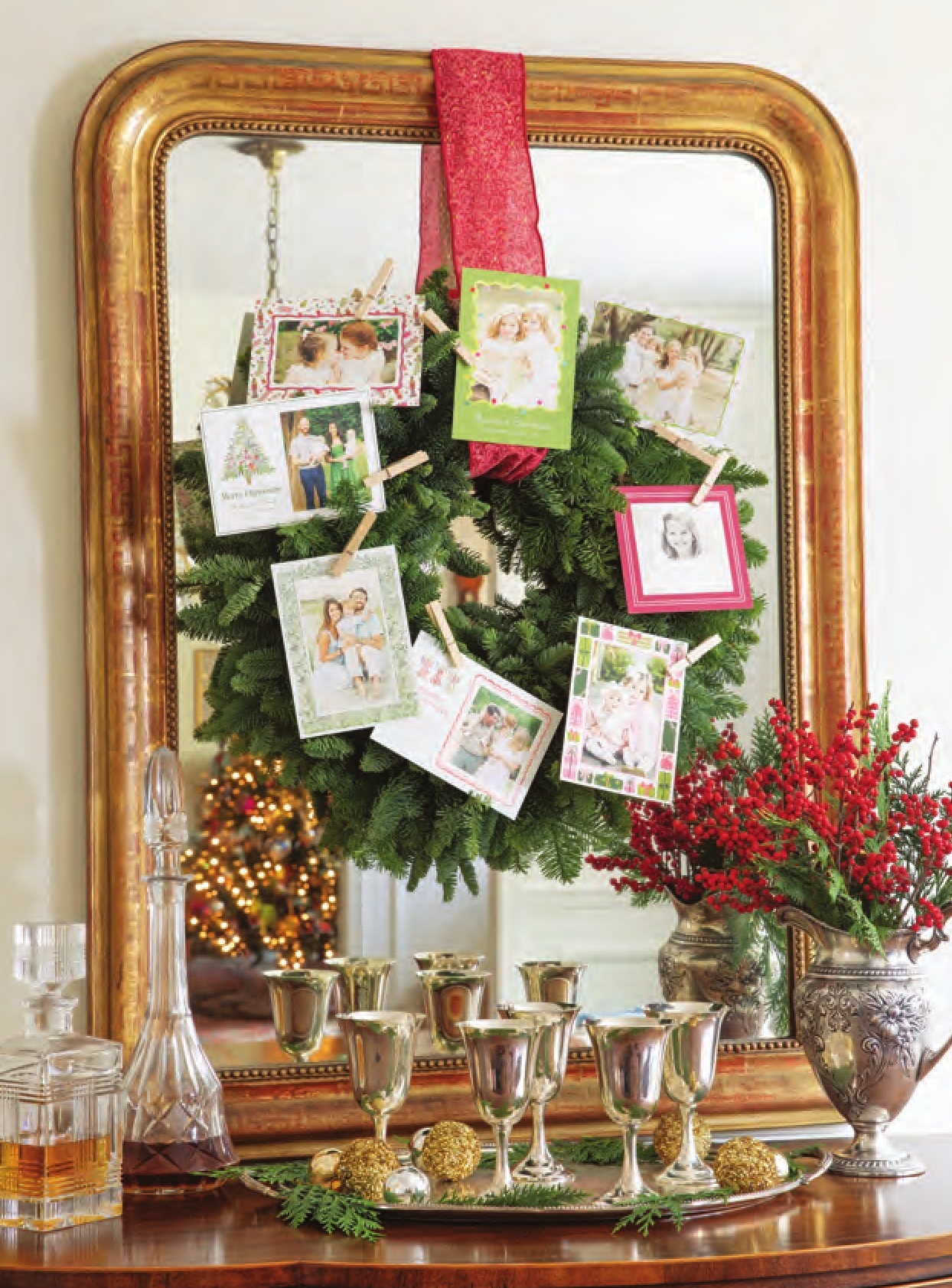 A wreath hanging on a mirror, with Christmas cards clothespinned on.