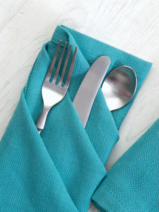 A napkin folded to make three pockets for cutlery.
