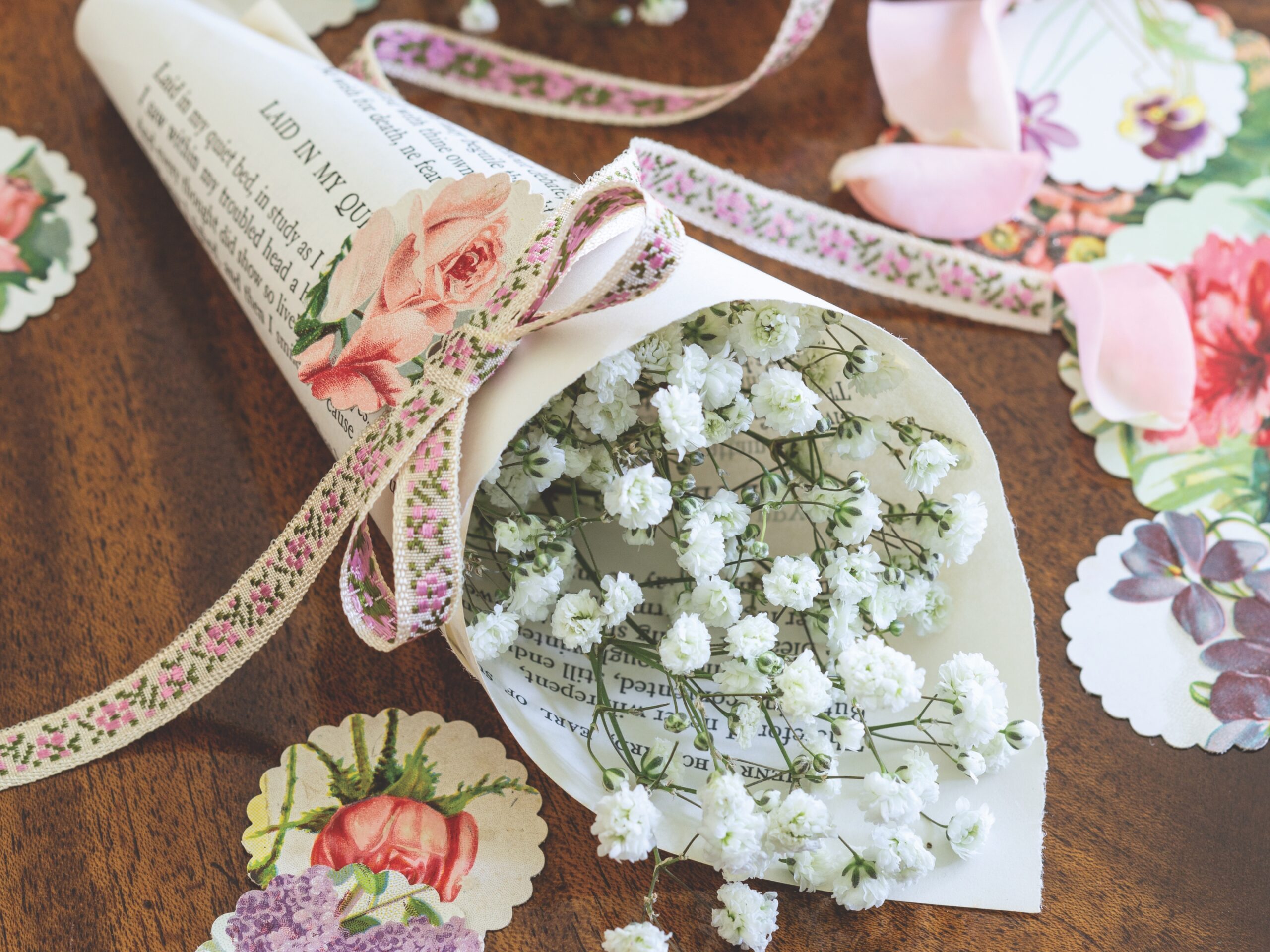The perfect tokens of affection, posies wrapped in printed poems make a delightfully diminutive offering for guests when tied with a dainty floral bow and a scalloped charm.