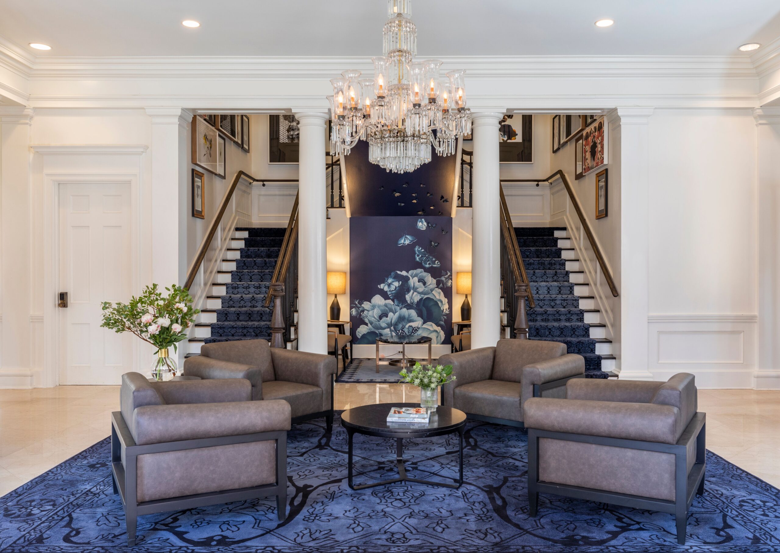 Hailing from Nashville’s Belle Meade Plantation, a twinkling antique crystal chandelier elevates this seating area surrounded by gallery walls of artwork by female Southern artists. 
