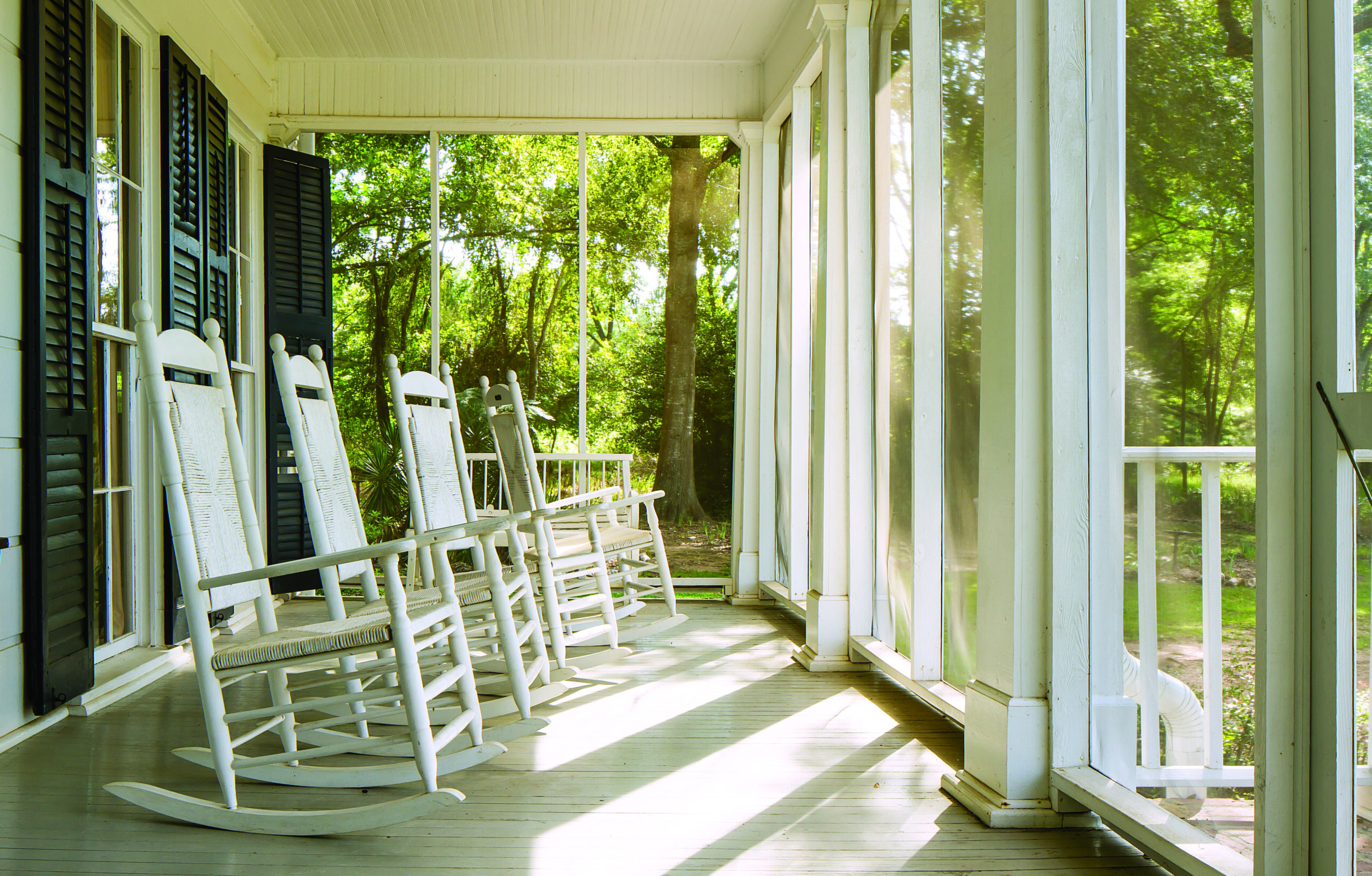 The broad front porch with rocking chairs at Flannery O'Connor's Southern farmhouse.