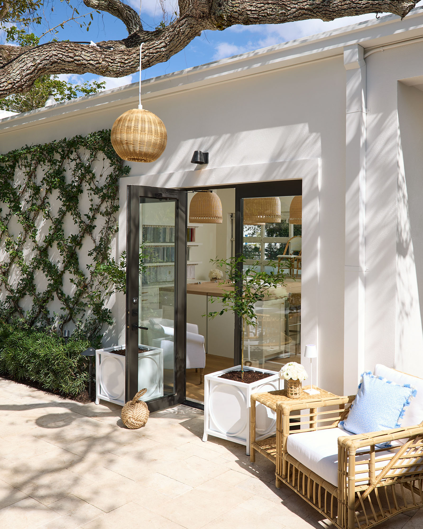 The exterior of the Serena and Lily store, with a trellis, outdoor furniture, and a wicker pendant light.