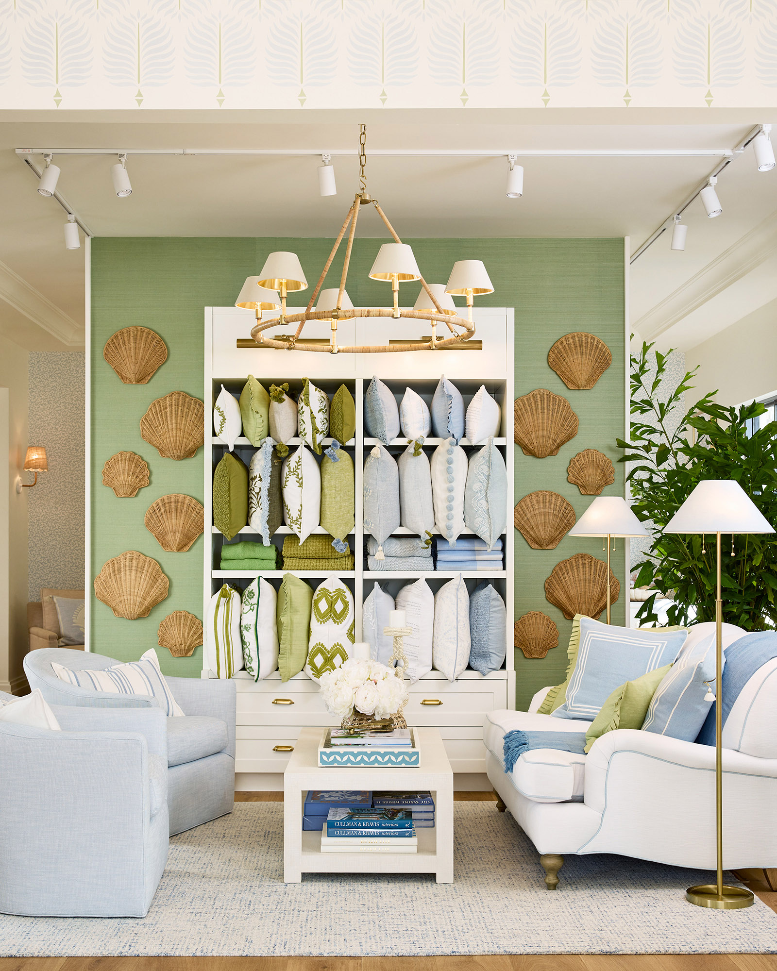 The interior of the Serena and Lily store, with coastal accents including a green wall decorated with wicker seashells and blue-and-white furniture.