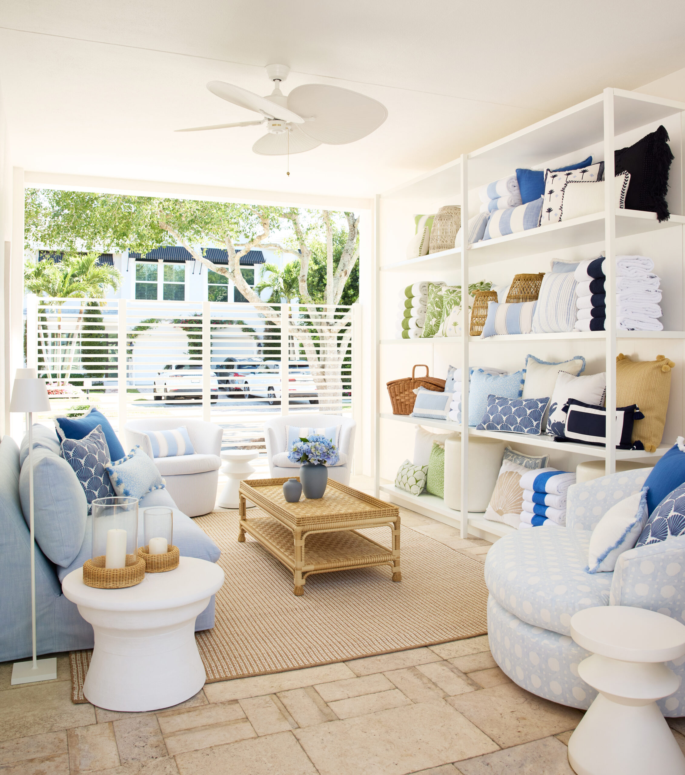The interior of the Serena and Lily store, with wall-to-wall windows, shelves of pillows, a light blue color palette, and cozy seating.