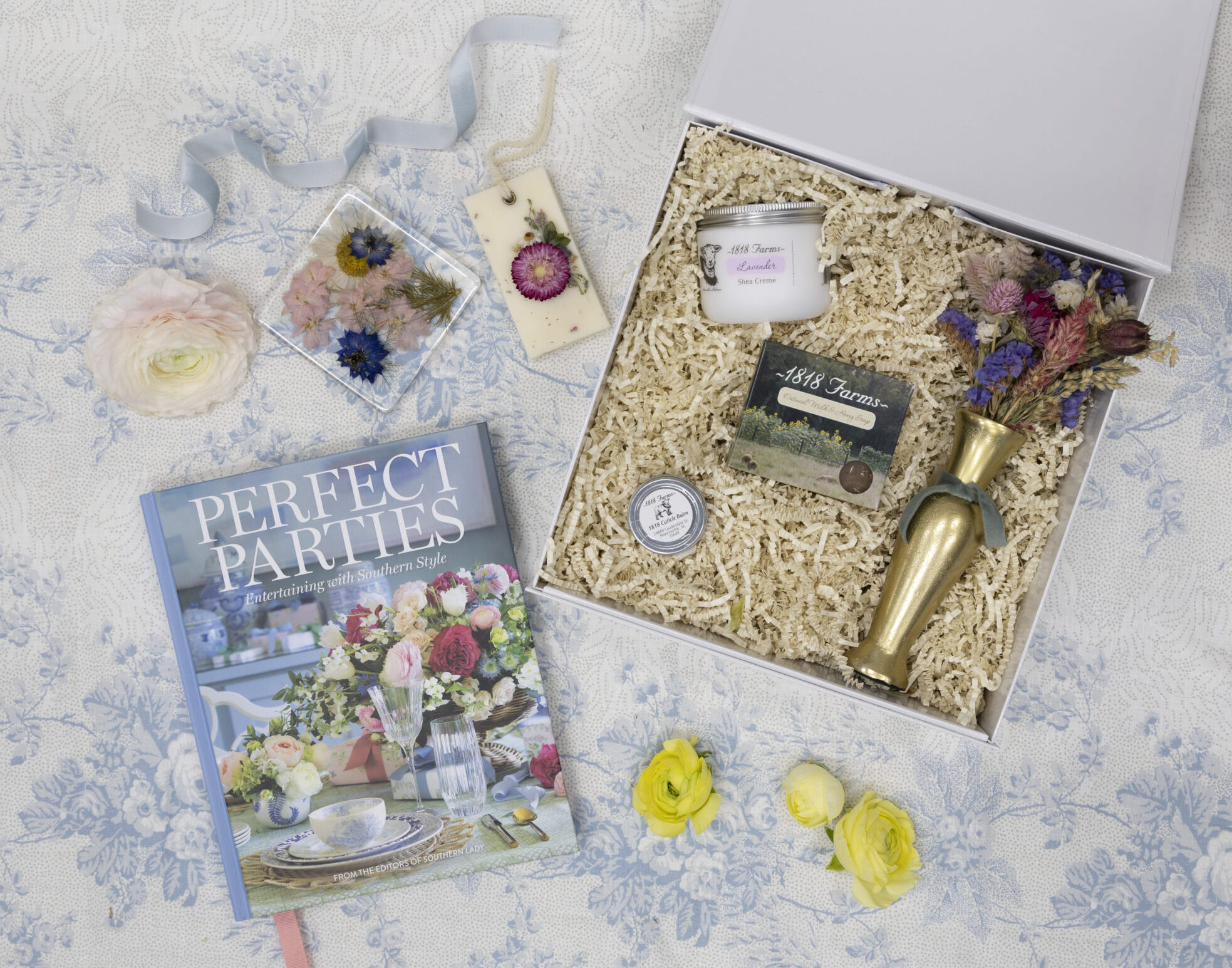 Southern Lady's hardcover book Perfect Parties, and a gift box from 1818 Farms with dried flowers, wax sachets, balms, and a coaster.